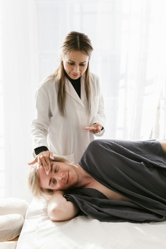 A practitioner performing a holistic therapy treatment on a relaxed patient in a spa setting.